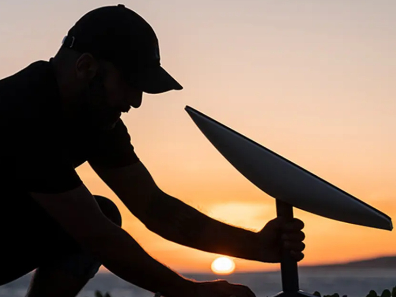 A professional technician securely installing a Starlink satellite dish on a rooftop in Houston, TX, ensuring clear satellite visibility for optimal internet performance.